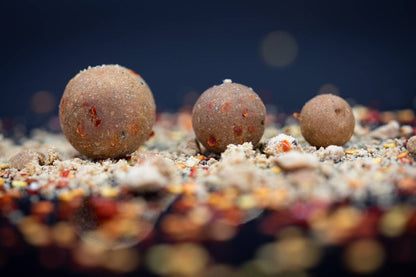 Протеинови топчета DYNAMITE BAITS Big Fish Peppered Squid Boilies - 1кг на фона на риболовни съставки.