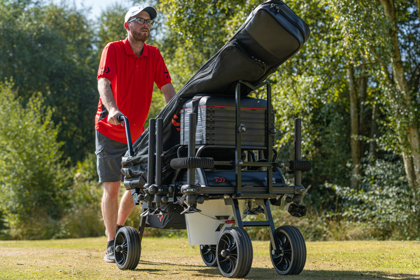 Количка за багаж Daiwa DAIWA FOLD N GO MATCH BARROW с рибарски такъми на природа.