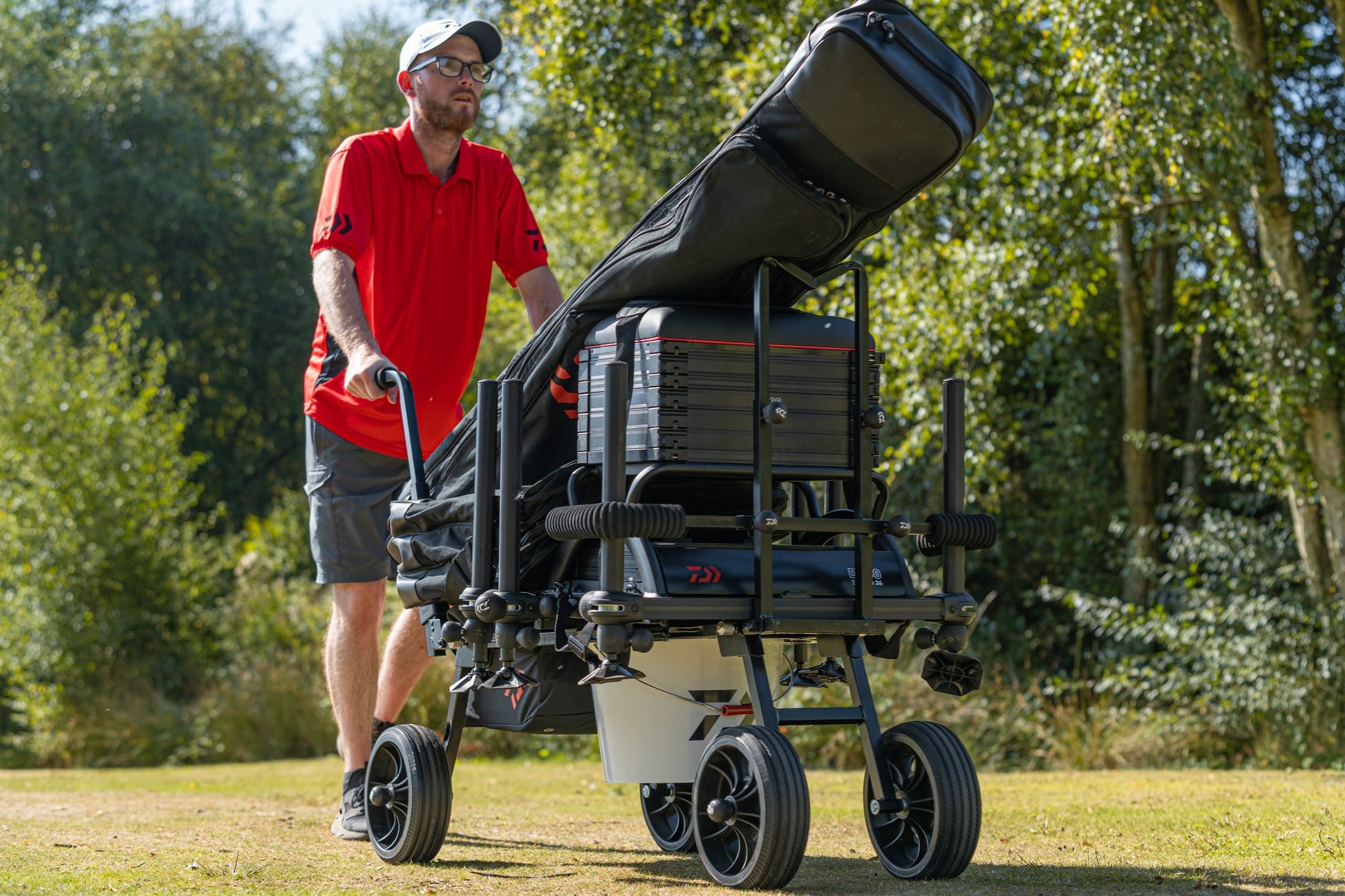 Количка за багаж Daiwa DAIWA FOLD N GO MATCH BARROW с рибарски такъми на природа.