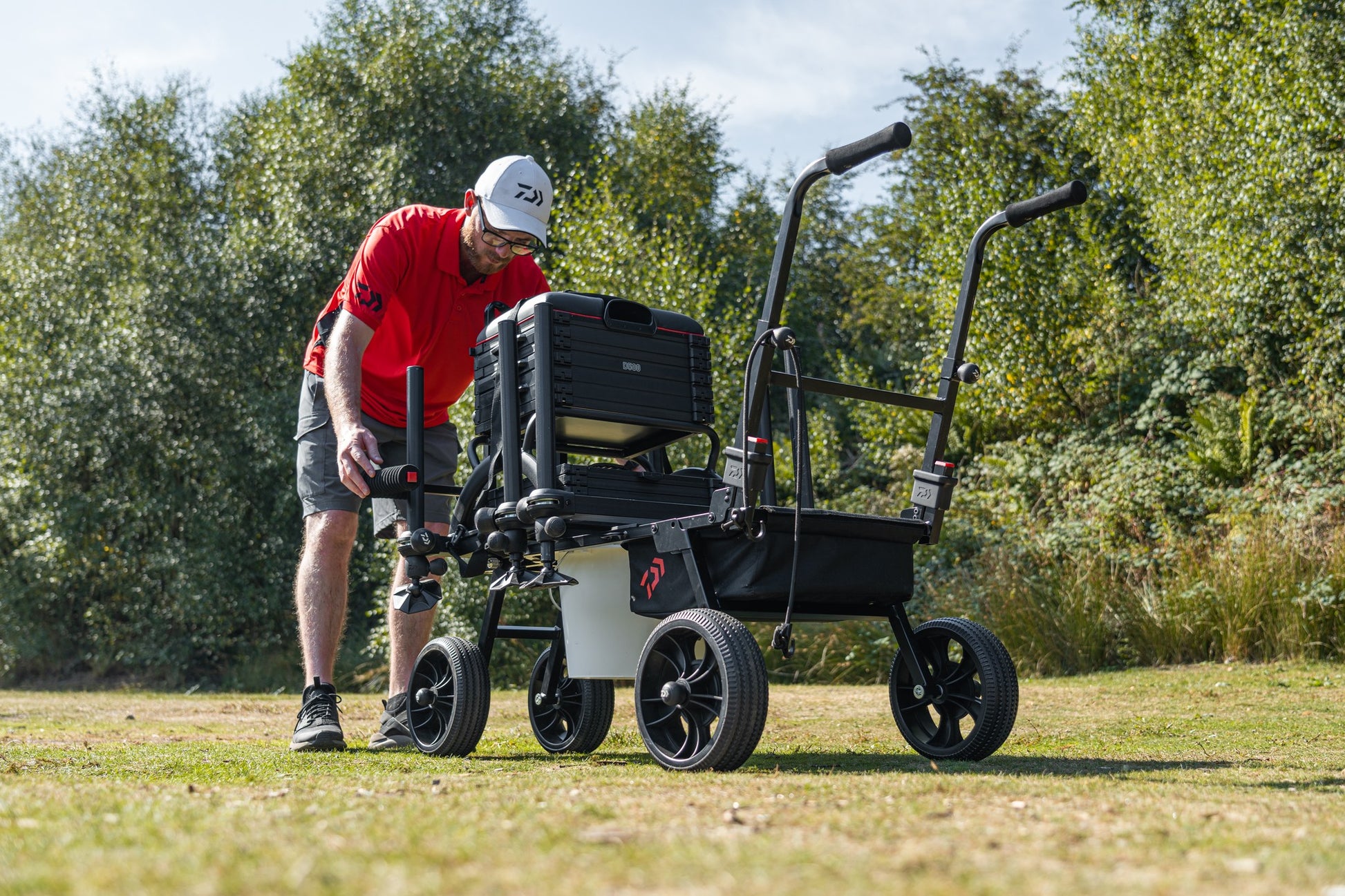Количка за багаж Daiwa DAIWA FOLD N GO MATCH BARROW с рибарски такъми на открито.