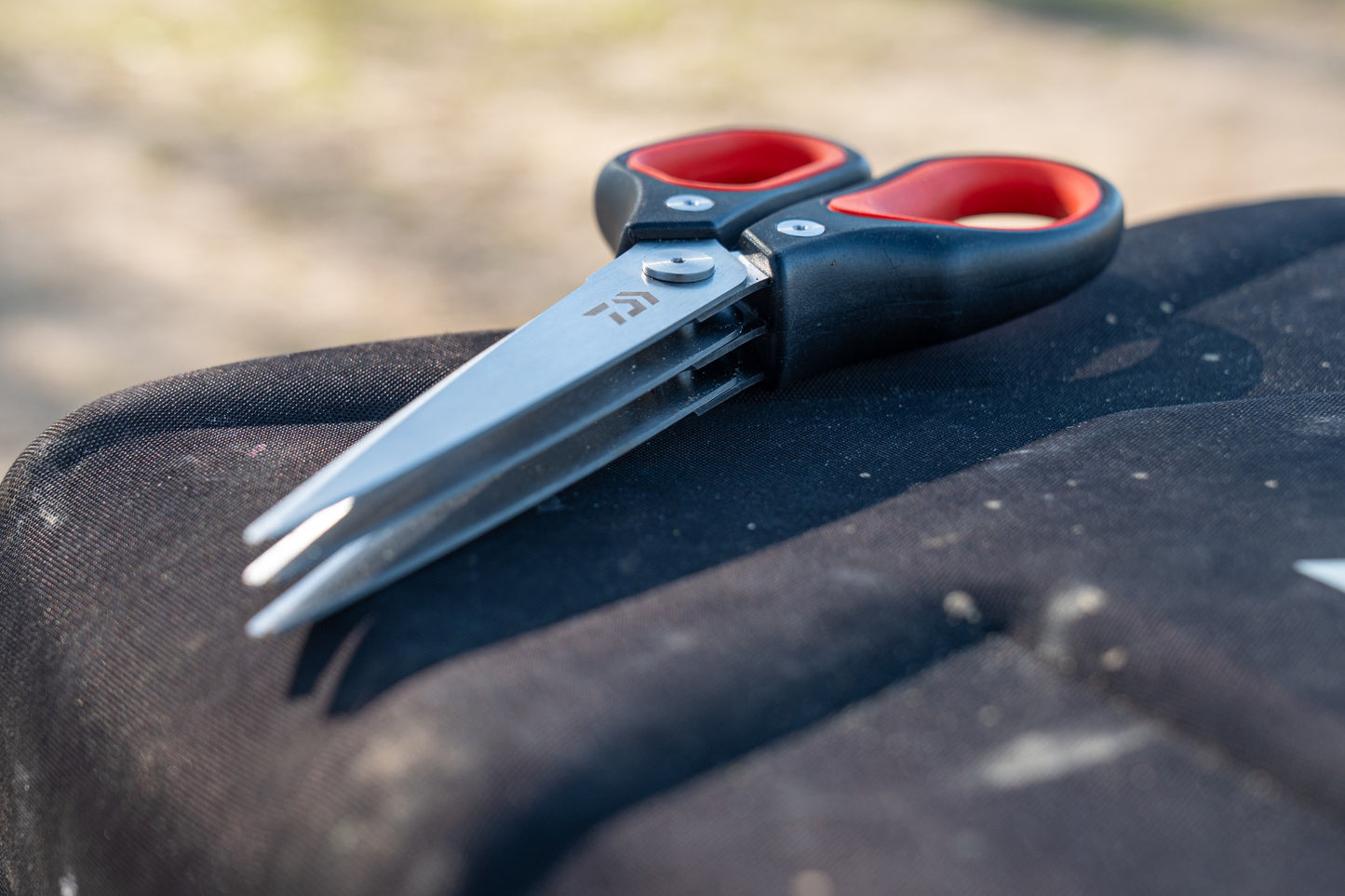 Тройна ножица за стръв DAIWA N'ZON TRIPLE BLADE WORM SCISSORS на черен фон, идеални за риболов.