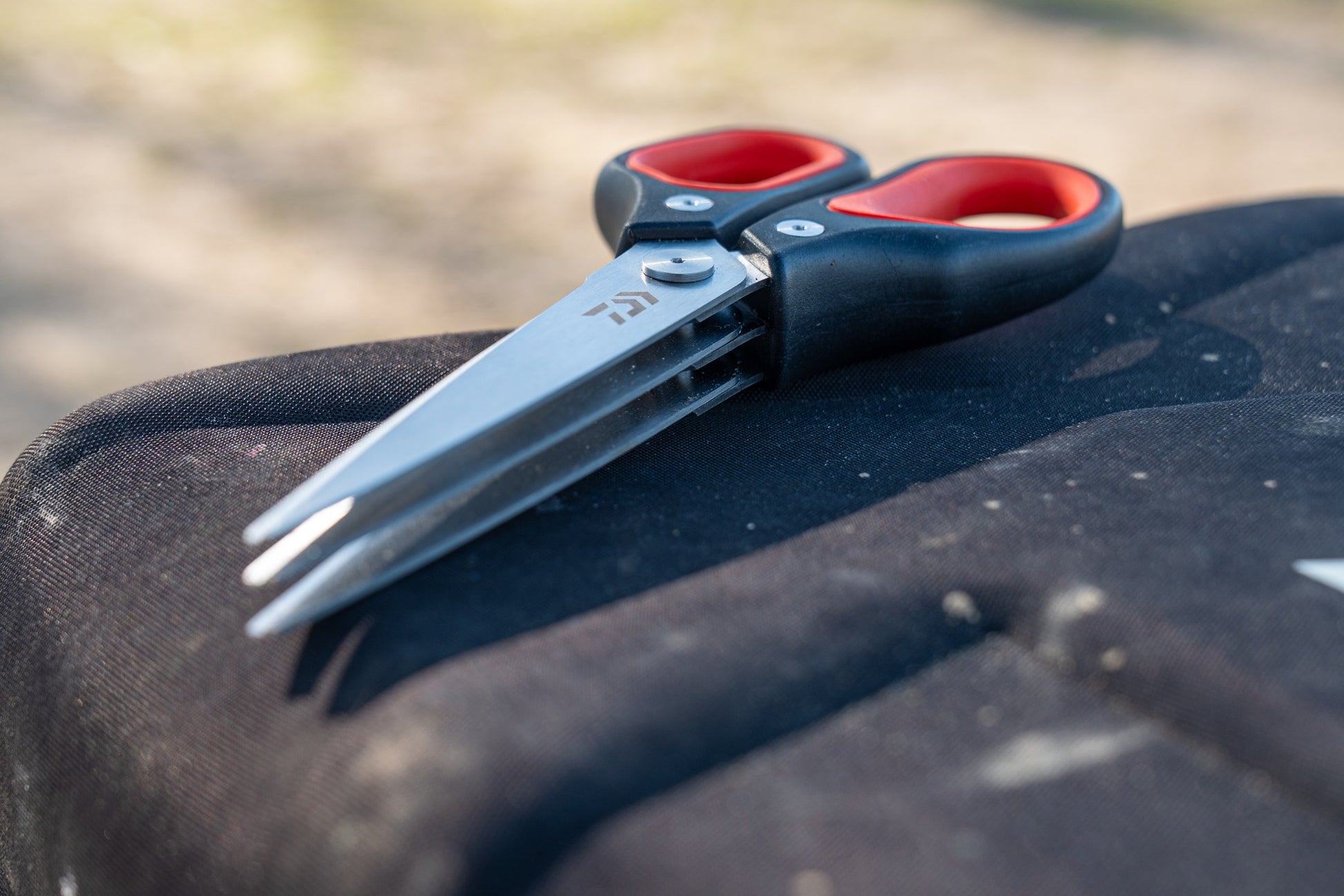 Тройна ножица за стръв DAIWA N'ZON TRIPLE BLADE WORM SCISSORS на черен фон, идеални за риболов.