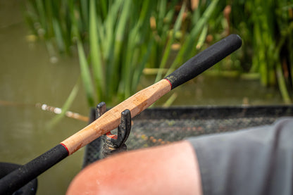 Фидер въдици DAIWA TOURNAMENT SLR - New model 2025 в риболовна среда, детайл на дръжка и ръка.