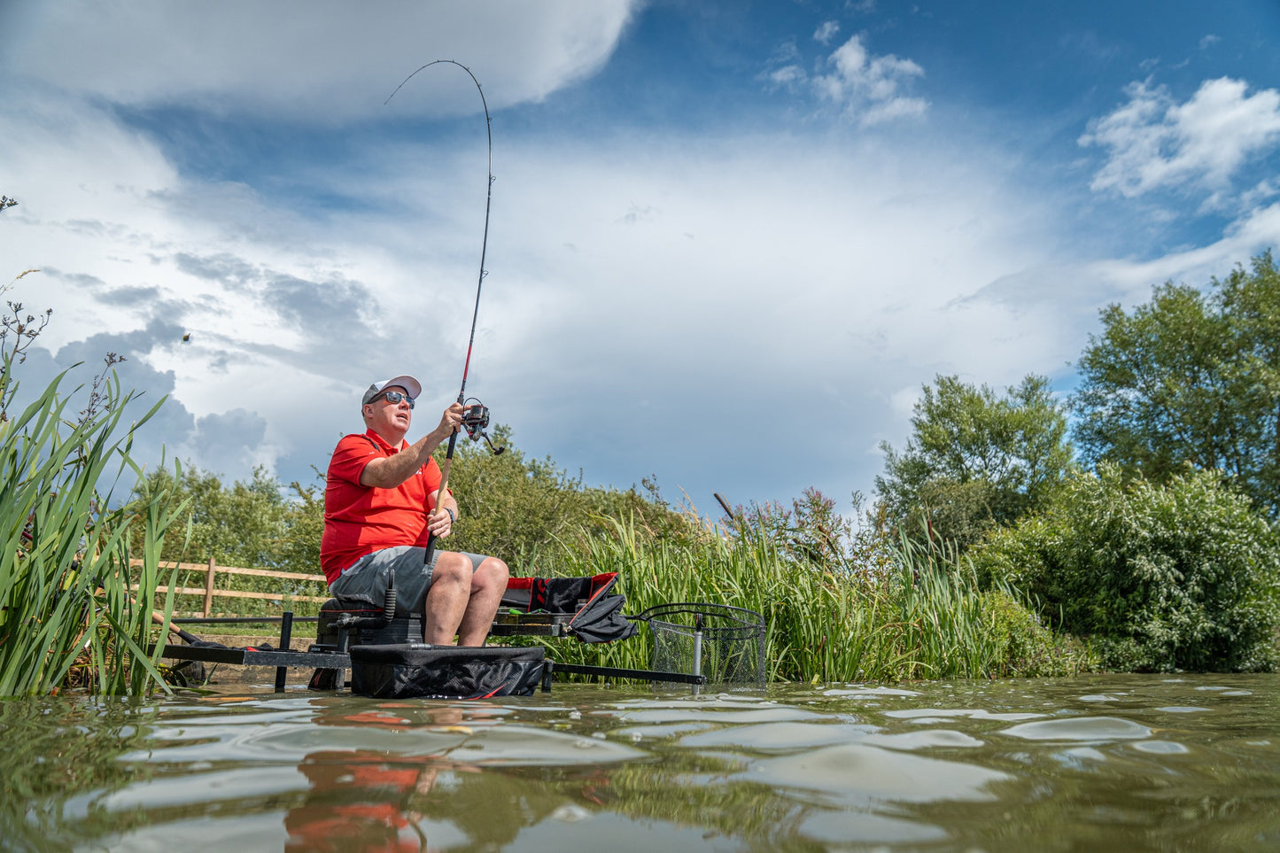Риболов с Фидер въдици DAIWA TOURNAMENT SLR - New model 2025 на красиво езеро в слънчев ден.