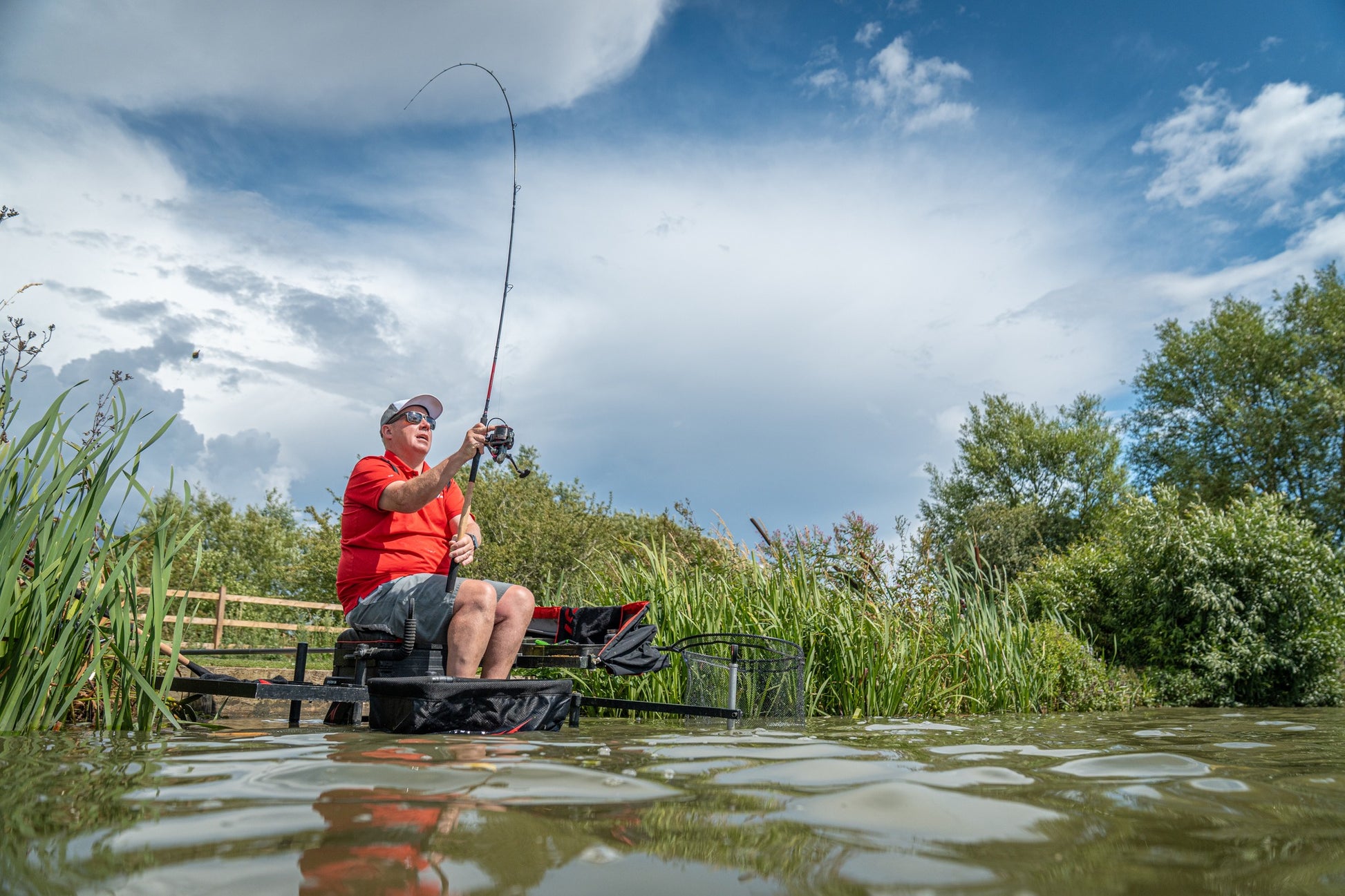 Риболов с Фидер въдици DAIWA TOURNAMENT SLR - New model 2025 на красиво езеро в слънчев ден.