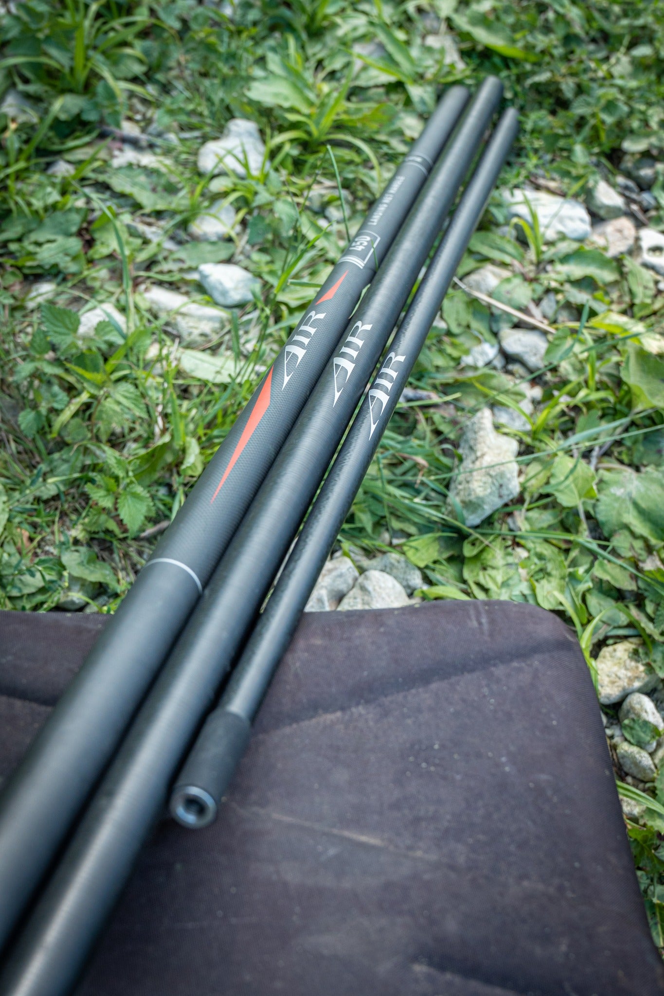 Дръжка за кеп DAIWA 25 AIR LANDING NET HANDLE 4.50m - риболовен аксесоар на трева и камъни.