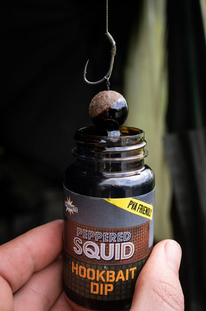 Дип Dynamite Baits Peppered Squid Concentrate - 100ml в ръка, идеален за риболов с примамки.