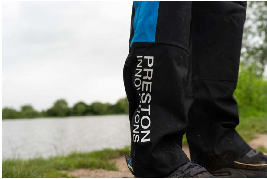 Водоустойчив панталон PRESTON DF ULTRA TROUSERS на рибар край водоем с удобни детайли.