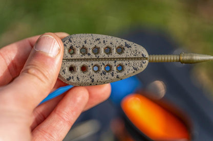 Метод хранилка PRESTON ICS IN-LINE BANJO XR FEEDERS - XL, показана в ръката на рибар.