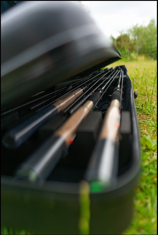 Твърд калъф за въдици MAVER MV-R HARD ROD PROTECTOR CASE - 191x20x26cm с въдици в него на зелена морава.
