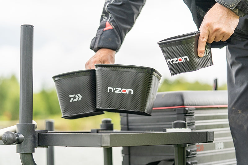 Кутия за стръв DAIWA NZON STACKING EVA BAIT BOX - 4 PINT в ръката на рибар, готова за работа на риболов.