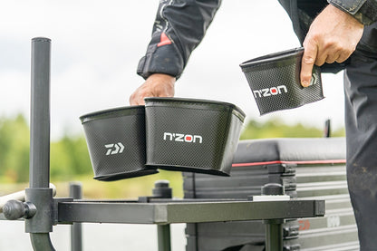 Кутия за стръв DAIWA NZON STACKING EVA BAIT BOX - 4 PINT в ръката на рибар, готова за работа на риболов.