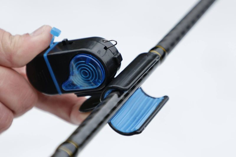 Сигнализатор Fil Fishing MINI BITE ALARM, монтиран върху въдица с черен и син дизайн, удобен за риболов.