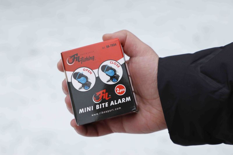 Сигнализатор Fil Fishing MINI BITE ALARM в ръката, опакован в кутия от два броя с опции отворено и затворено.