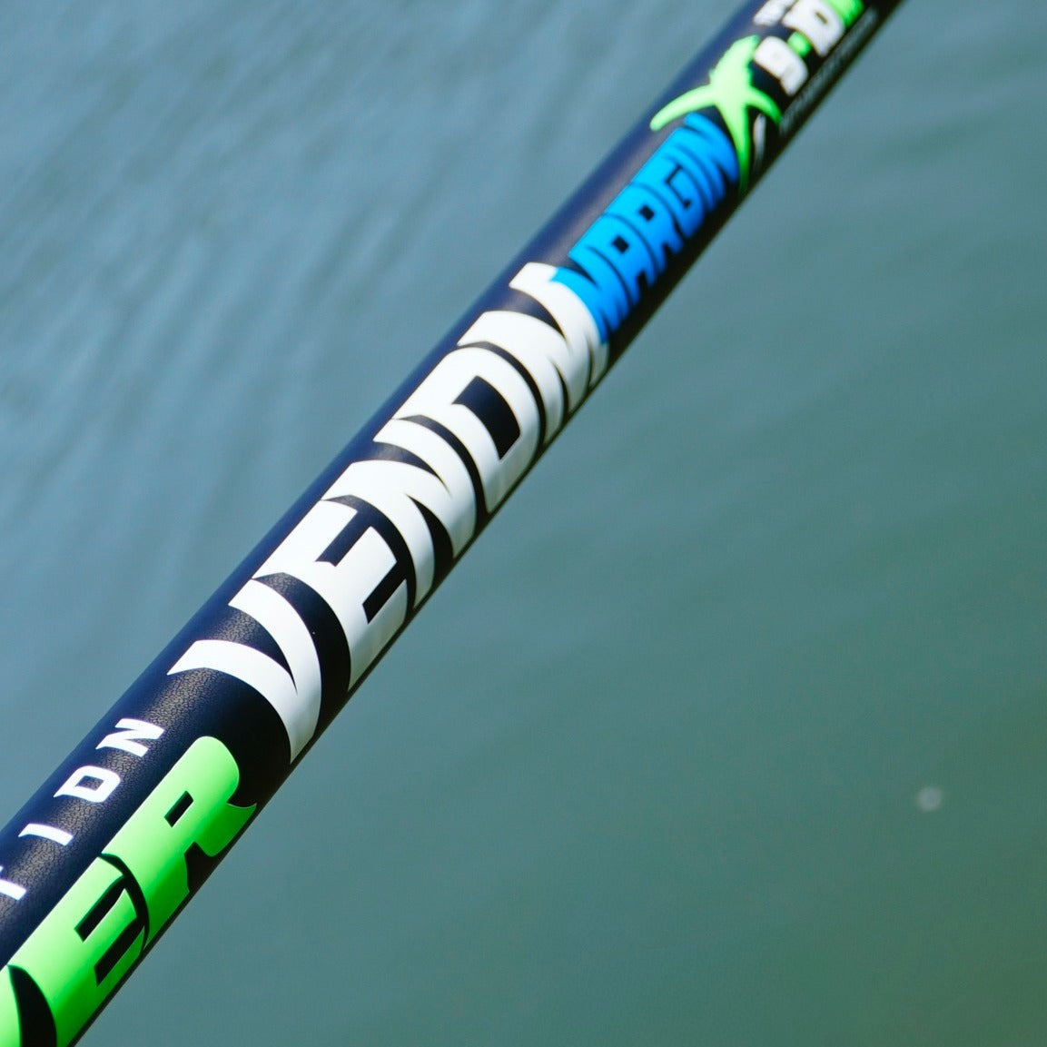 Щека MAVER POLE VENOM MARGIN 10M + MINI EXT /Модел 2026/ на фона на водна повърхност, идеална за риболов.