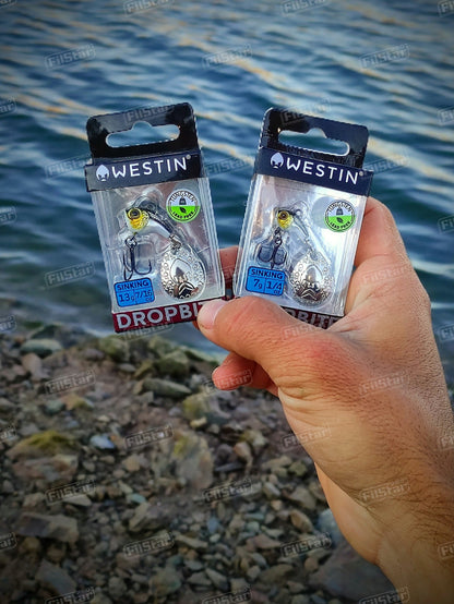 Спинер Westin DropBite Tungsten Spin Tail Jig на риболовния бряг с пакети на продукта.